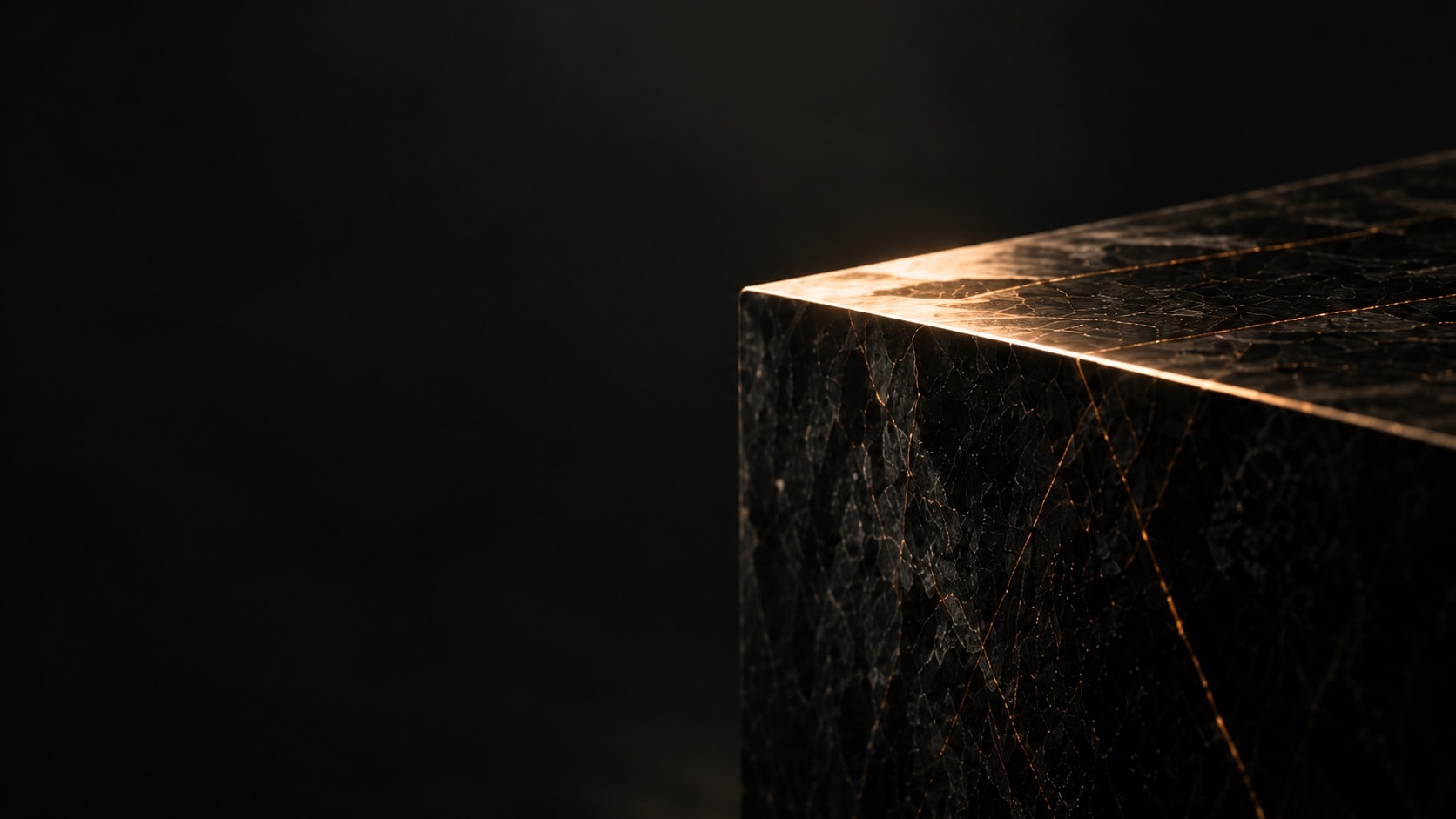 Black marble block with copper veins catching a single beam of light